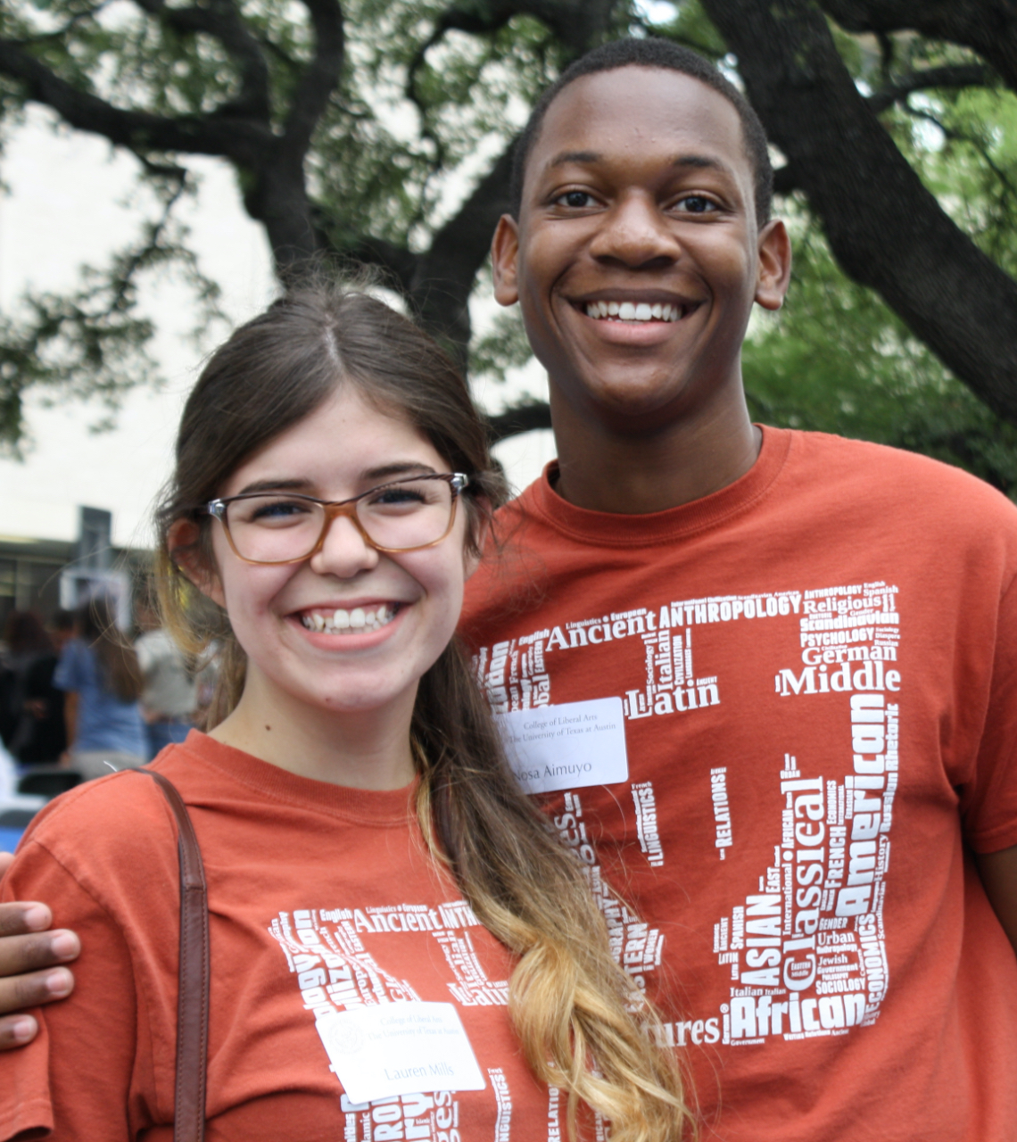 two students at an outdoor university event pose for the camera