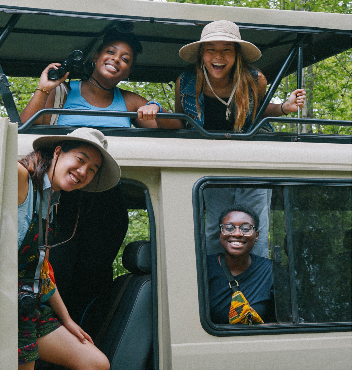 four students in and on a van pose for a photo while on a jungle tour